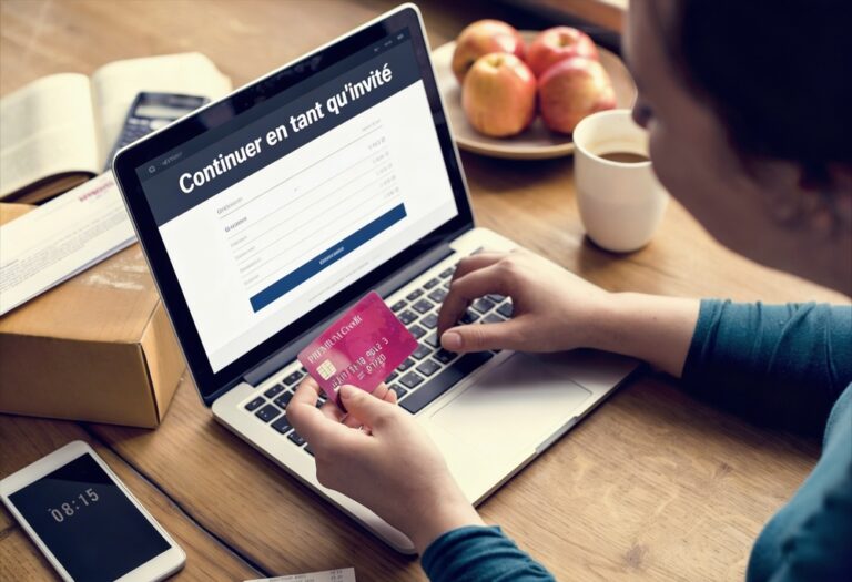 photographie-mains-tenant-carte-bancaire-sur-ordinateur-portable-achat-ecommerce-inscription-continuer-en-tant-qu-invite