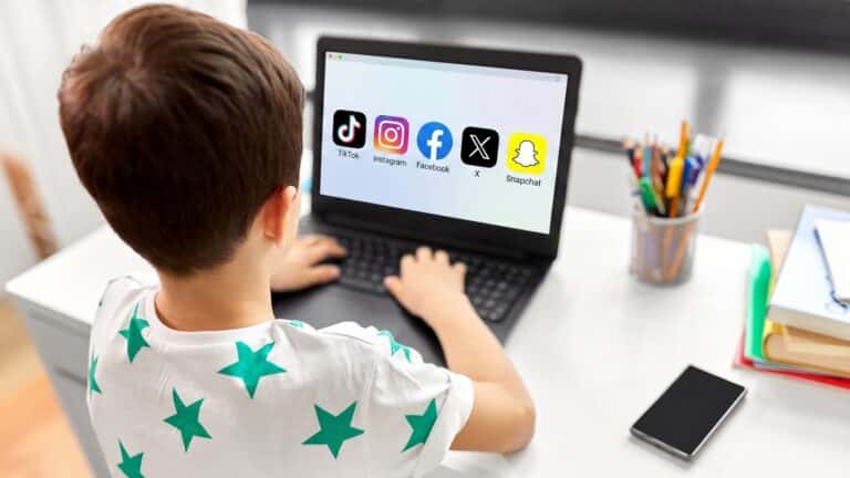 photographie-enfant-de-dos-sur-ordinateur-avec-logos-reseaux-sociaux